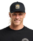 Man wearing a black cap with a logo and matching black shirt on a gray background