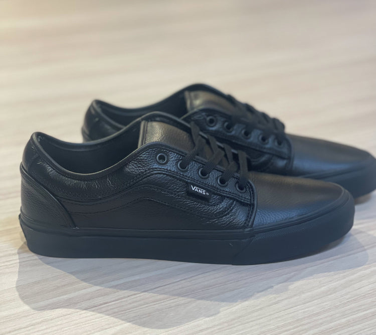 A pair of Vans Chukka Low sidestripe black leather shoes with POPCUSH™ technology displayed on a light background.