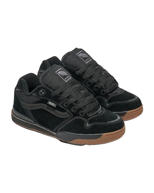 Black sneakers with brown soles on a light gray background