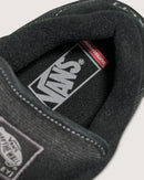 Close-up of a black sneaker with Vans branding on a light gray background