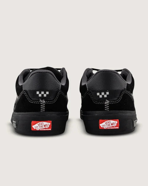 Black sneakers with a visible brand logo on a light gray background