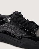 Close-up of a black sneaker with white stitching on a light gray background