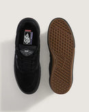 Black Vans sneaker with brown sole on a light gray background