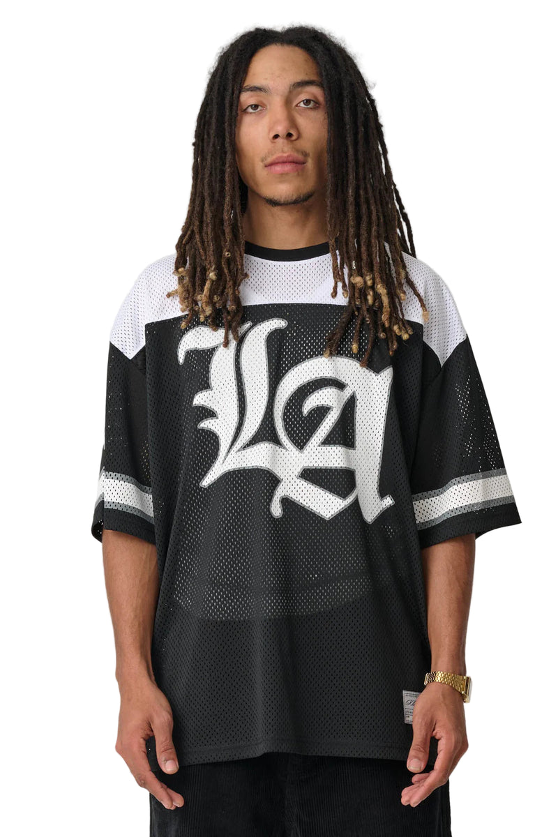 Person wearing a black and white sports jersey with 'LA' design on a plain background