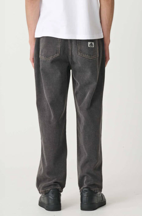 Person wearing dark gray jeans and a white shirt on a white background