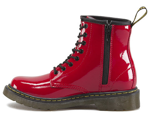 A red patent leather youth boot with a lace-up closure and a brand tag attached to it.
