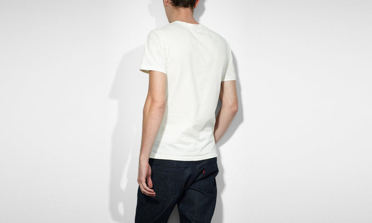 A male model wearing a white Levi's crew slim t-shirt with a marshmallow graphic on the front.