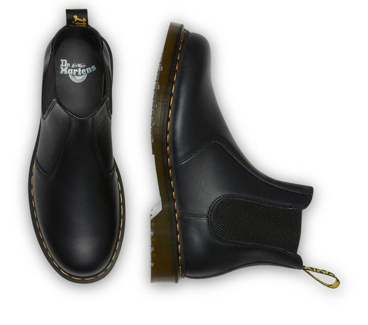 A pair of Dr Martens 2976 Black Nappa Leather Chelsea Boots with yellow welt stitching and the brand's logo visible.