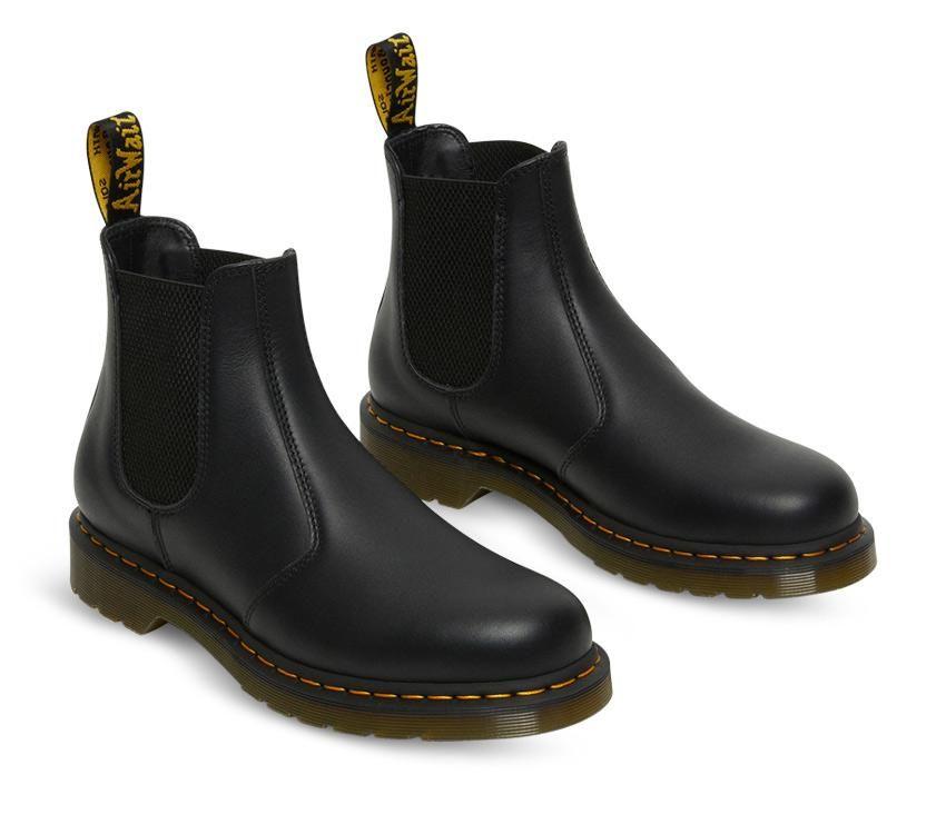 A pair of Dr Martens 2976 Black Nappa Leather Chelsea Boots with yellow welt stitching and the brand's logo visible.