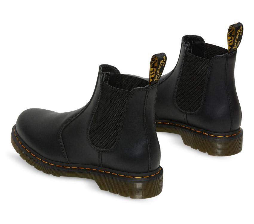 A pair of Dr Martens 2976 Black Nappa Leather Chelsea Boots with yellow welt stitching and the brand's logo visible.