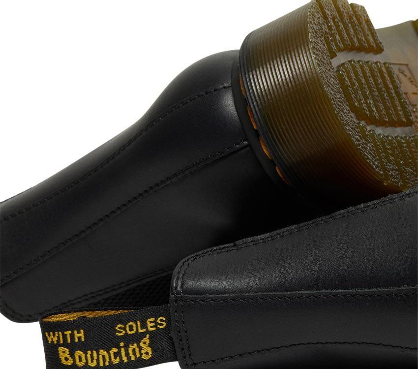 A pair of Dr Martens 2976 Black Nappa Leather Chelsea Boots with yellow welt stitching and the brand's logo visible.