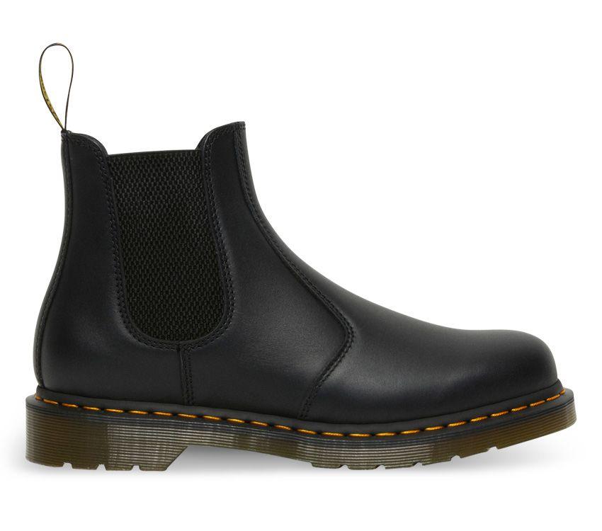 A pair of Dr Martens 2976 Black Nappa Leather Chelsea Boots with yellow welt stitching and the brand's logo visible.