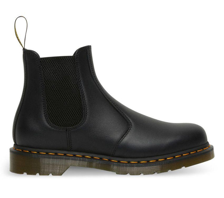 A pair of Dr Martens 2976 Black Nappa Leather Chelsea Boots with yellow welt stitching and the brand's logo visible.