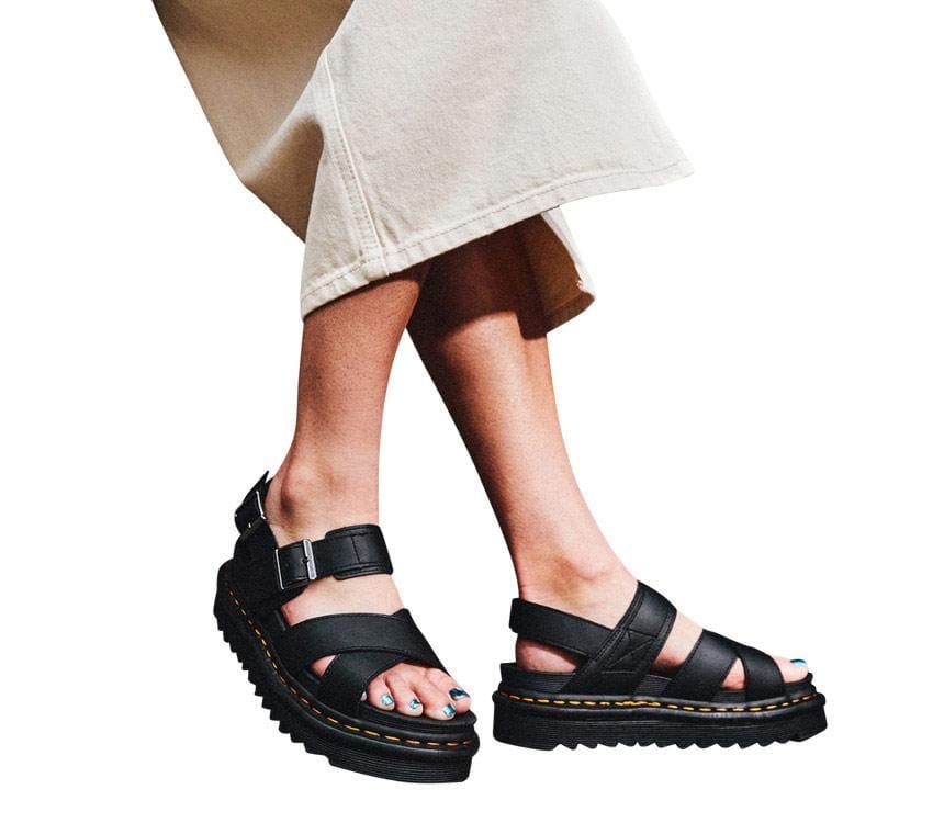 A pair of Dr Martens Voss II Black Hydro Leather Sandals with gunmetal buckles on a white background.