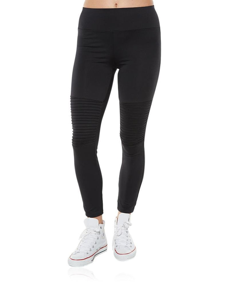 A pair of black LKI Admiral leggings with front panelling and back pockets, worn with white sneakers.