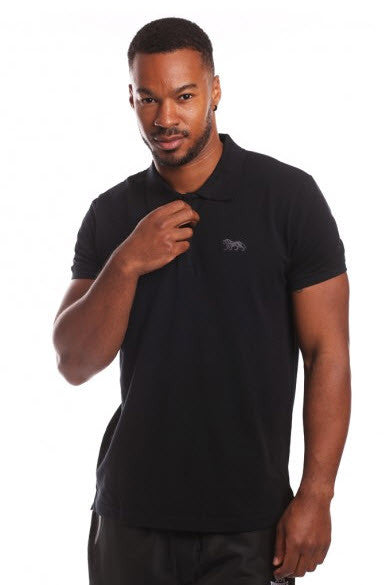 A man wearing a black cotton pique Lonsdale Eric polo shirt with chest embroidery and a sleeve print.