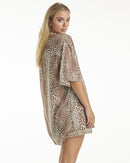 A female model wearing a leopard print shirt tied at the waist with shorts, posing against a neutral background.