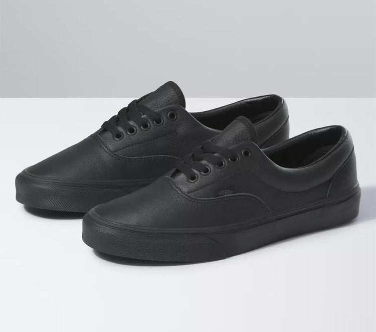 A pair of black leather Vans Era skate shoes displayed against a neutral background.