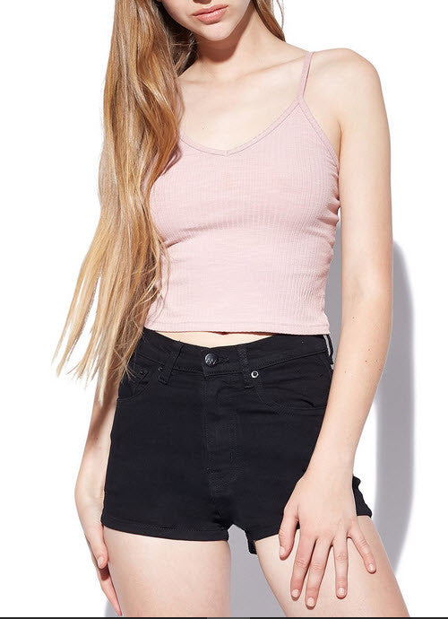A pair of rigid blue denim kick shorts on a mannequin against a white background.